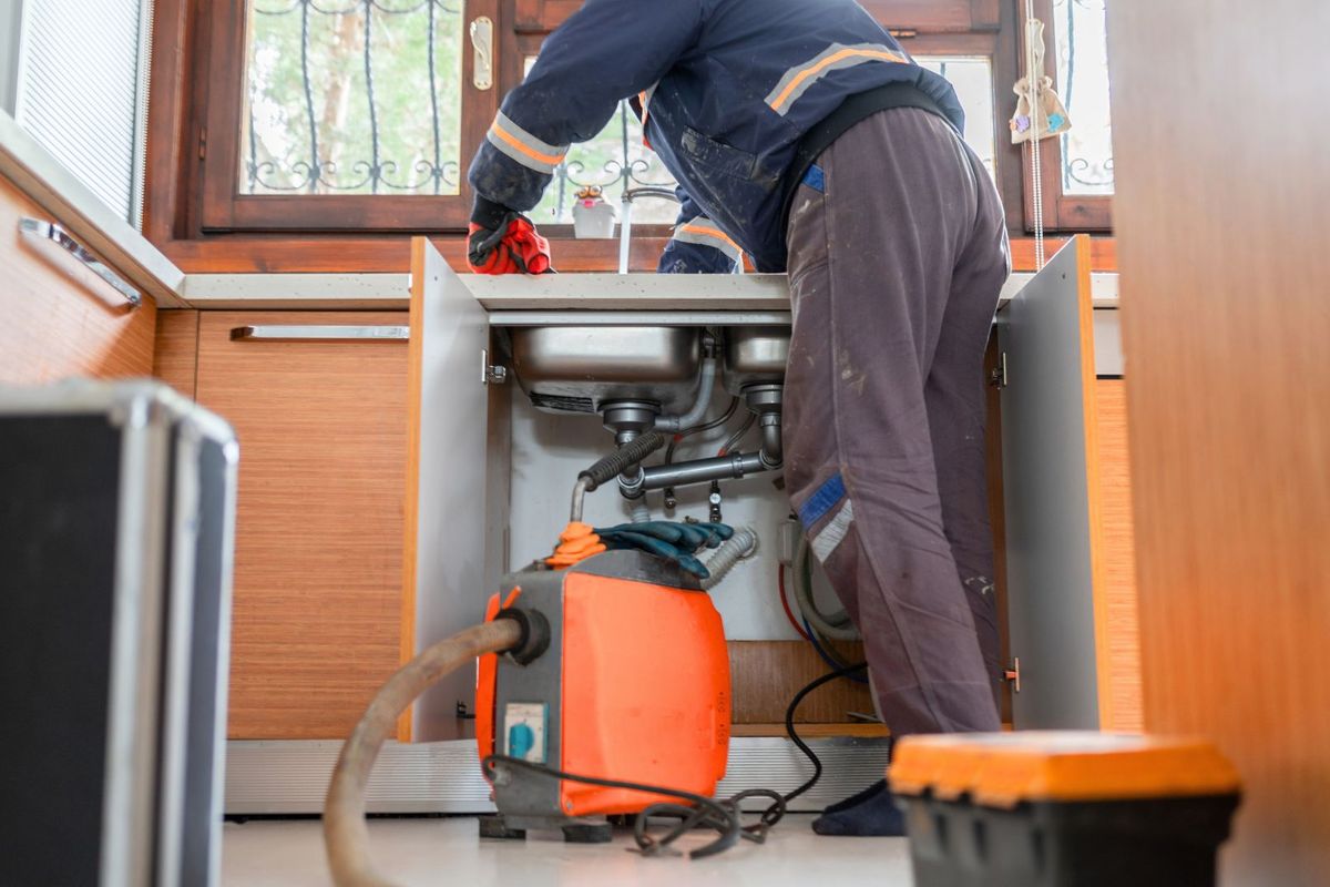 Máquina rotativa de desentupimento em uso numa cozinha