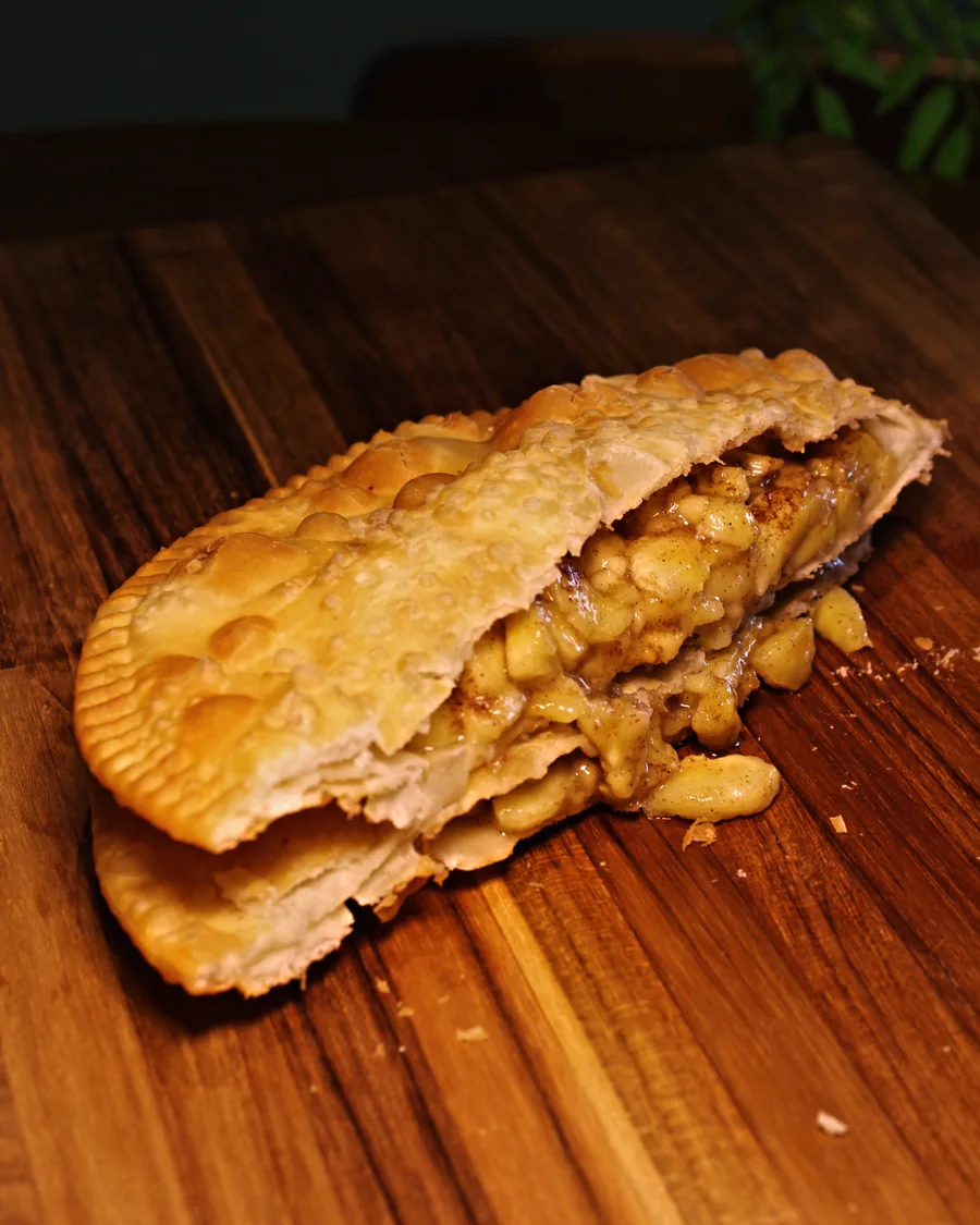 Pastel Banana com Canela aberto, mostrando o recheio, servido na Pastello