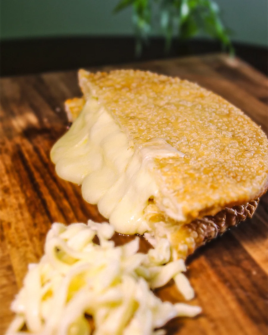 Pastel Queijo aberto, mostrando o recheio, servido na Pastello