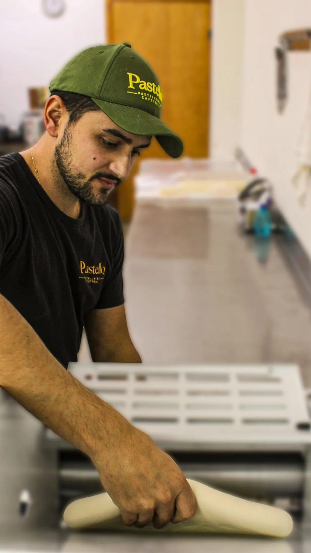 Mãos preparando a massa do pastel na cozinha da Pastello